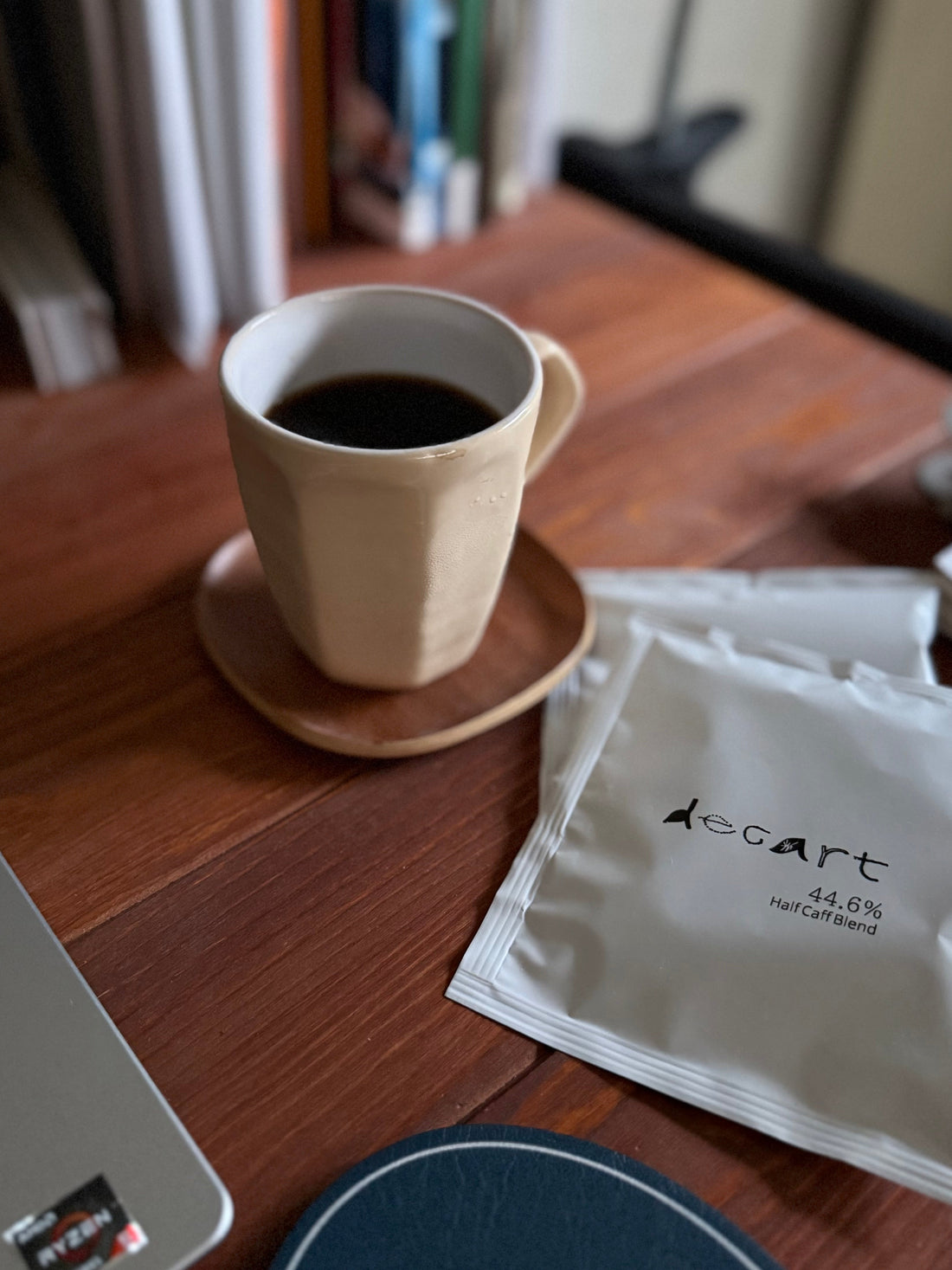 デスクでコーヒーを飲むビジネスパーソンと逆U字の法則イメージ｜decart labディカートラボ